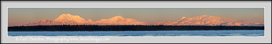 A panoramic photo of the Wrangell Mountains, Mount Drum, Mount Sanford, Mount Zanetti, Mount Wrangell, from Willow Lake, alpenglow in the wintertime, Wrangell-St. Elias National Park, Alaska.