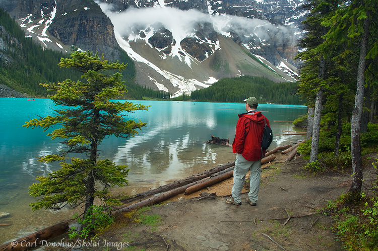 Tourist watching people canoeing on Moraine Lake, Banff, Canada.