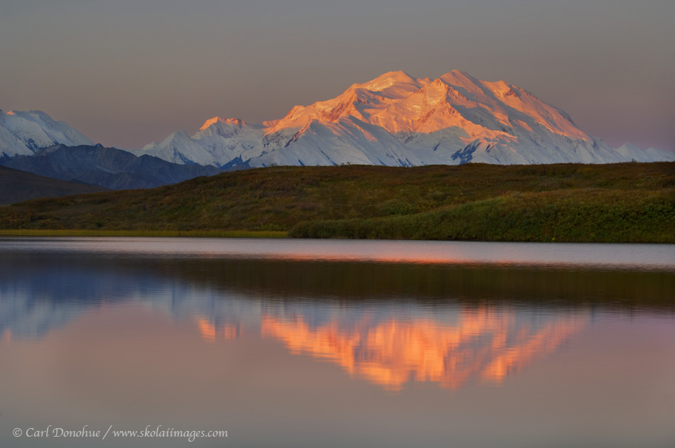 "Denali", officially known as Mt. McKinley, the highest peak in North America, stands above the Alaska Range, a small kettle pond returning a perfect reflection. Denali National Park, Alaska.