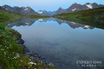 Beautiful alpine lake and reflection of the Chugach Mountains on a backpacking trip in Wrangell St. Elias National Park, Alaska.